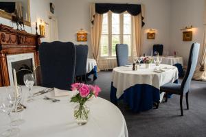 uma sala de jantar com duas mesas com flores em Chirnside Hall Hotel em Chirnside