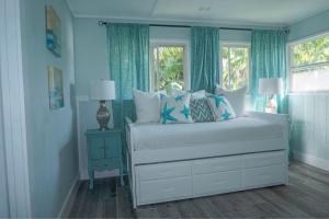 a bedroom with a bed with blue curtains and a window at Waimea Bay Luxury Estate Views & Hot Tub in Haleiwa