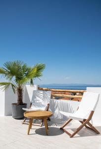 a pair of chairs and a coffee table on a patio at Palm Suites in Pefkochori