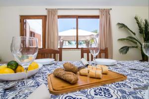 einen Tisch mit einem Teller mit Käse und Weingläsern in der Unterkunft Villa Girassol - By Dalma Portuguesa in Olhos de Água