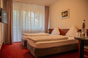 pokój hotelowy z 2 łóżkami i oknem w obiekcie Hotel Alpha w Stuttgarcie