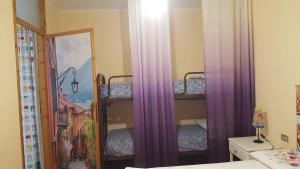 a bedroom with two bunk beds with purple curtains at LA PERLA DEL CENTRO LAGO DI COMO in Perledo