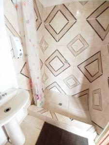 baño con lavabo blanco y suelo de baldosa. en Serenity Lodges Dominica en Marigot