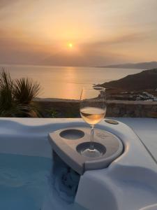 szklankę wina siedzącą na skraju basenu w obiekcie Villa Mandala w mieście Mykonos