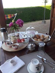 una mesa con una bandeja de comida y un tazón de pan en Les Glycines - Domaine Gilles Coperet, en Régnié