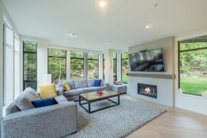Una sala de estar con chimenea y televisión. en Ravencrest by Outpost Whistler, en Whistler