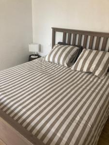 Una cama con dos almohadas de rayas encima. en Mas Paradiso, en Allemagne-en-Provence