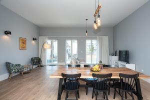 uma cozinha e sala de jantar com uma mesa de madeira e cadeiras em Porto XL no Porto