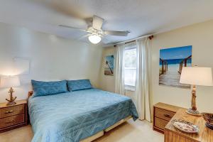 een slaapkamer met een blauw bed en een plafondventilator bij Driftwood Villa - 237 in Edisto Beach