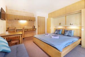 ein Schlafzimmer mit großem Bett und eine Küche in der Unterkunft Appartements Zum Arber in Bayerisch Eisenstein