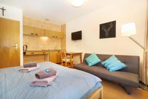 ein Schlafzimmer mit einem Bett und einer Couch mit Handtüchern darauf in der Unterkunft Appartements Zum Arber in Bayerisch Eisenstein + 28 Fotos