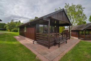 een kleine hut met een bank in een tuin bij Glenview Chalet Park in Inverness