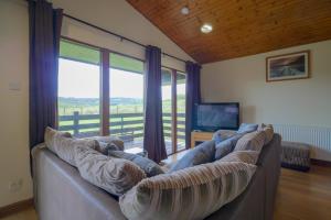 a living room with a couch and a large window at Glenview Chalet Park in Inverness