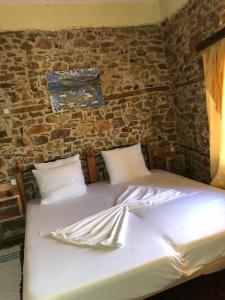 a bed with white sheets and utensils on it at Rosas Home in Pogradec