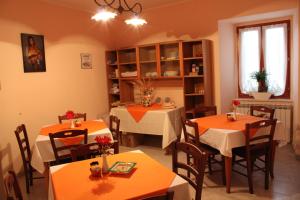 een eetkamer met 2 tafels en stoelen met oranje tafels bij B&B Montagano in Montagano