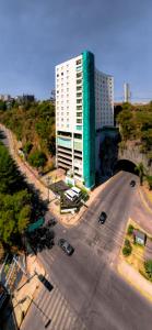 ein großes weißes Gebäude in einer Straße neben einem Parkplatz in der Unterkunft Gamma Ciudad de Mexico Santa Fe in Mexiko-Stadt