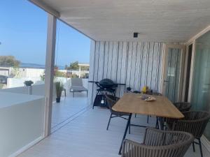un patio con tavolo e sedie sul balcone. di BUQEZ ECO RESORT - Beach Villa 37 and 40 a Pakoštane