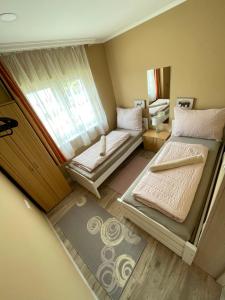 a small room with two beds and a window at Lilla Apartman in Balatonkeresztúr