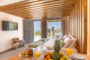 Agkidia的住宿－Naxos Pantheon Luxury Apartments，一间房间,配有一张床和一张桌子,上面有水果