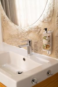 a bathroom sink with a mirror and a soap dispenser at FONTE SANTA Manor House in Vila Nova de Gaia +38 photos