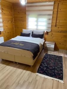 a bedroom with a bed in a room with wooden walls at New toprak suite in Uzungöl
