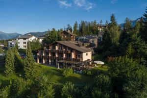 an aerial view of a resort with trees and buildings at T3 Hotel Mira Val in Flims