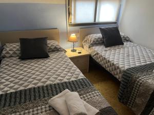 モライラにあるAPARTAMENTO 1 LINEA MORAIRAのベッド2台、テーブル(ランプ付)が備わる客室です。