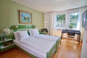 Schlafzimmer mit einem Bett, einem Schreibtisch und einem Fenster in der Unterkunft Hotel La Balance self check-in in Biel