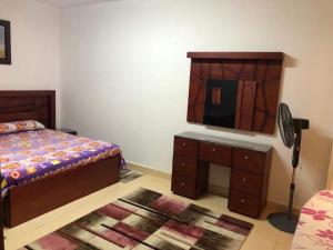 ein Schlafzimmer mit einem Bett und eine Kommode mit einem Spiegel in der Unterkunft بناية الصبيحي in Irbid