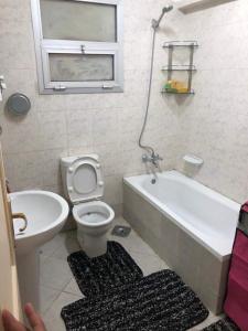 ein Badezimmer mit einem WC, einer Badewanne und einem Waschbecken in der Unterkunft بناية الصبيحي in Irbid