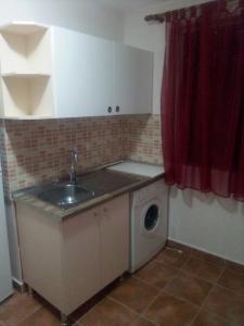 a kitchen with a sink and a washing machine at Sonce - Tirana in Tirana
