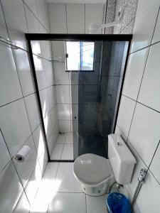 a small bathroom with a toilet and a shower at Pinheiro Flat Hotel in Ibiapina