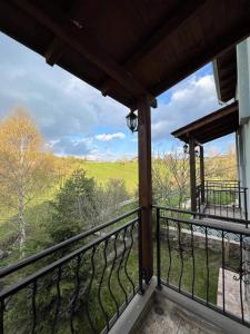 a balcony with a view of a green field at Vila Mata in Voskopojë
