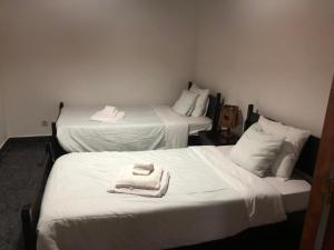 twee bedden met handdoeken bovenop in een kamer bij Casa do vermelho in Povoação