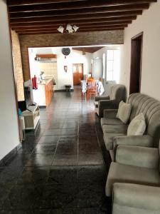 a living room with couches and a table and a kitchen at Casa do vermelho in Povoação