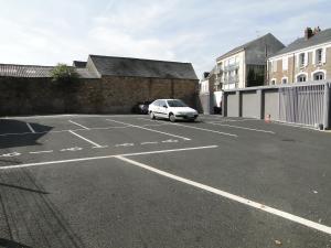 un estacionamiento con un coche blanco estacionado en él en The Originals Access, Hôtel Cholet Gare, en Cholet