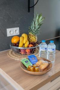 - une table avec un bol de fruits et une assiette de nourriture dans l'établissement Cosy Apparts Saintes, à Saintes