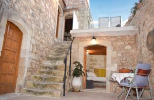 una casa de piedra con una escalera que conduce a una puerta en CASA CANTICO, en Margarítai