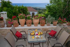 een tafel en stoelen op een balkon met planten bij CASA CANTICO in Margarítai