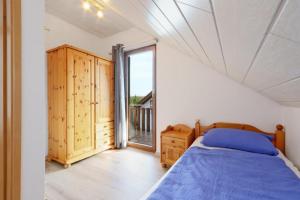 1 dormitorio con cama y ventana grande en Ferienhaus Anne mit Sauna, See, Wald und Ruhe en Kirchheim