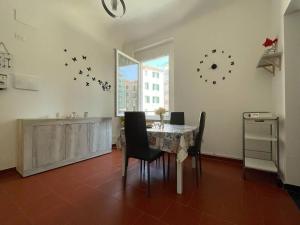 a dining room with a table and chairs and a clock on the wall at La casa del mare in Savona