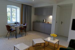 a living room with a kitchen and a table and chairs at LODGES EN PIERRES DOREES in Saint-Germain-Nuelles