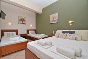a hotel room with two beds and a tv at Hotel Fani in Leptokarya +24 photos