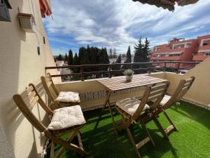 y balcón con césped y mesa de patio y sillas. en Apartamento tropical con piscina cerca de la playa en Torremolinos