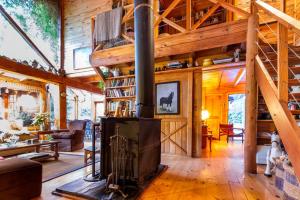 a living room with a fireplace in a wooden house at BOG Costa de Rio - Piscina climatizada y costa de rio in Villa La Angostura