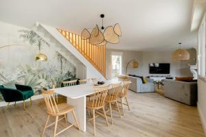 uma sala de jantar e sala de estar com uma mesa branca e cadeiras em La Villa l'Escale, somptueuse maison contemporaine em Angoulême