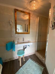 a bathroom with a sink and a mirror and a stool at Haus Frauenpreiss 67 in Cuxhaven