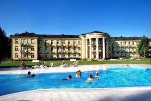 a group of people in a pool in front of a building at Rehabilitation Centre & SPA Draugystės sanatorija in Druskininkai