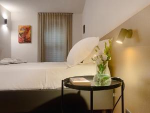 a bedroom with a bed with a vase of flowers on a table at Villa Verlengia in Montesilvano