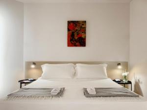 Un dormitorio con una gran cama blanca con una pintura encima. en Villa Verlengia en Montesilvano
